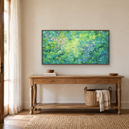 Flower-filled green panorama in a walnut-toned floating frame above a wood console with turned legs and a basket beneath