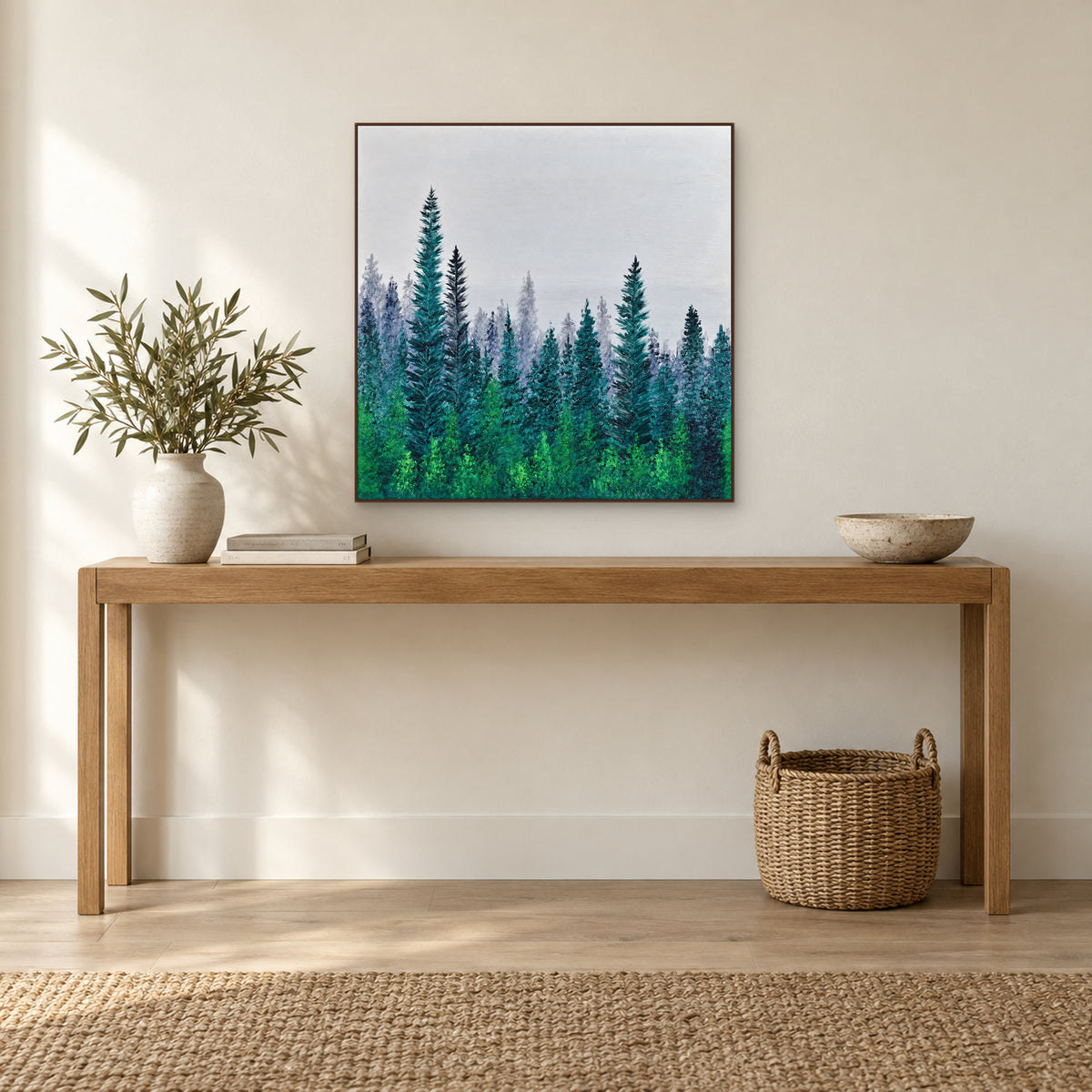 Walnut-tone framed pine forest painting above a slim wooden console with a ceramic vase and bowl
