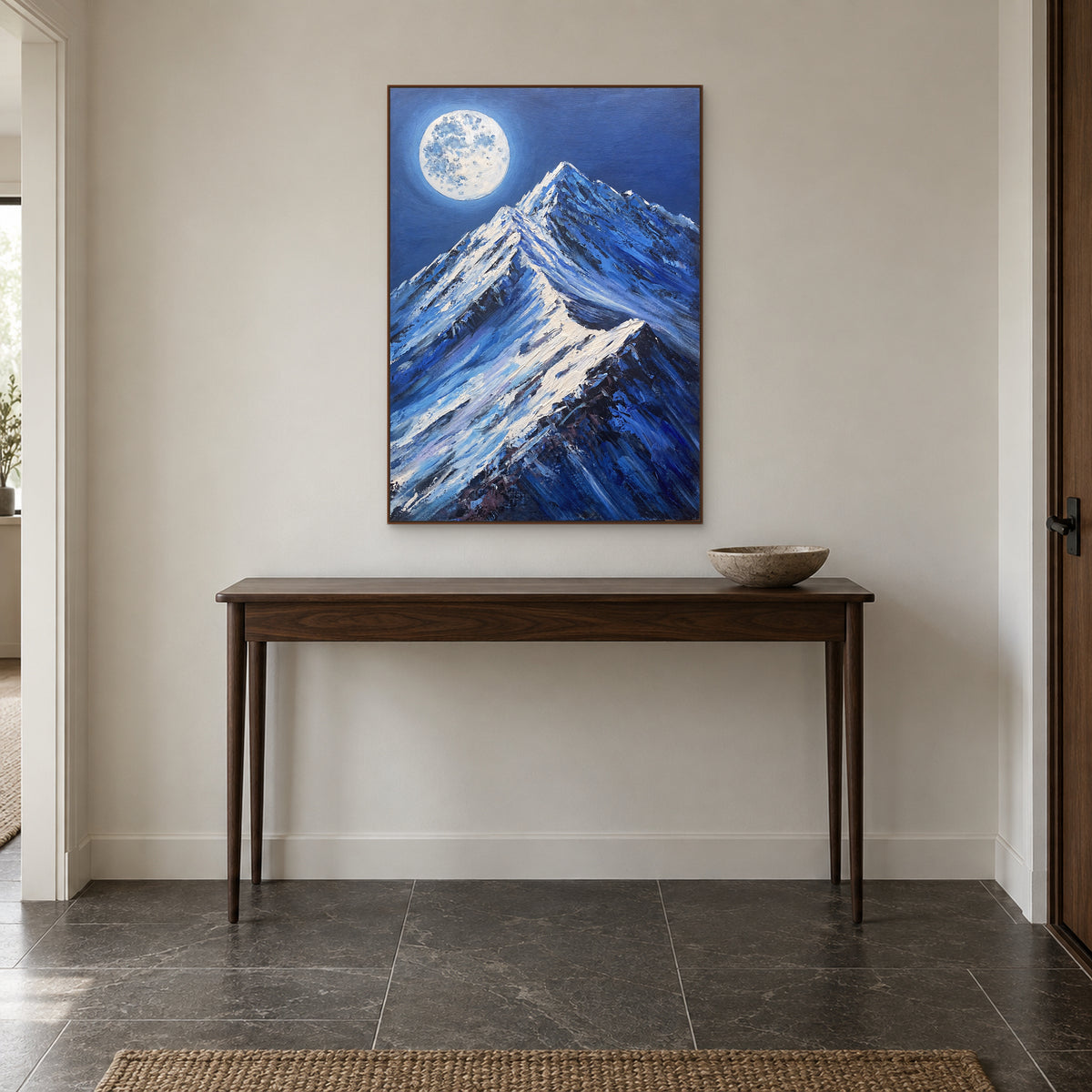 Moonlit snow peaks in a walnut-tone frame centred over a narrow wooden entryway console