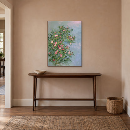 Vertical rose painting in a thin walnut-tone frame above an entryway console, with space between the frame and the tabletop decor