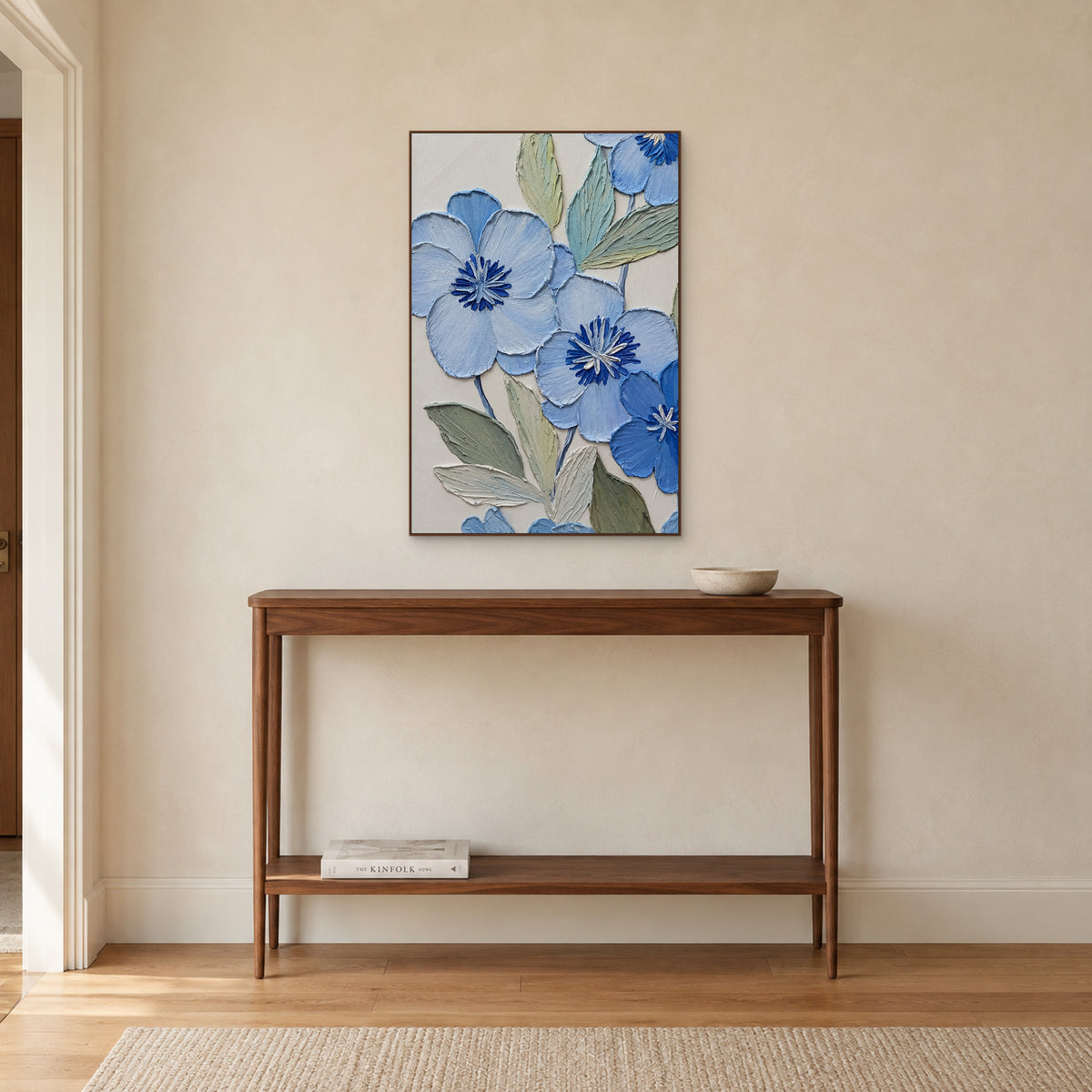 Vertical powder-blue flower painting in a walnut-tone frame above a wooden entryway console