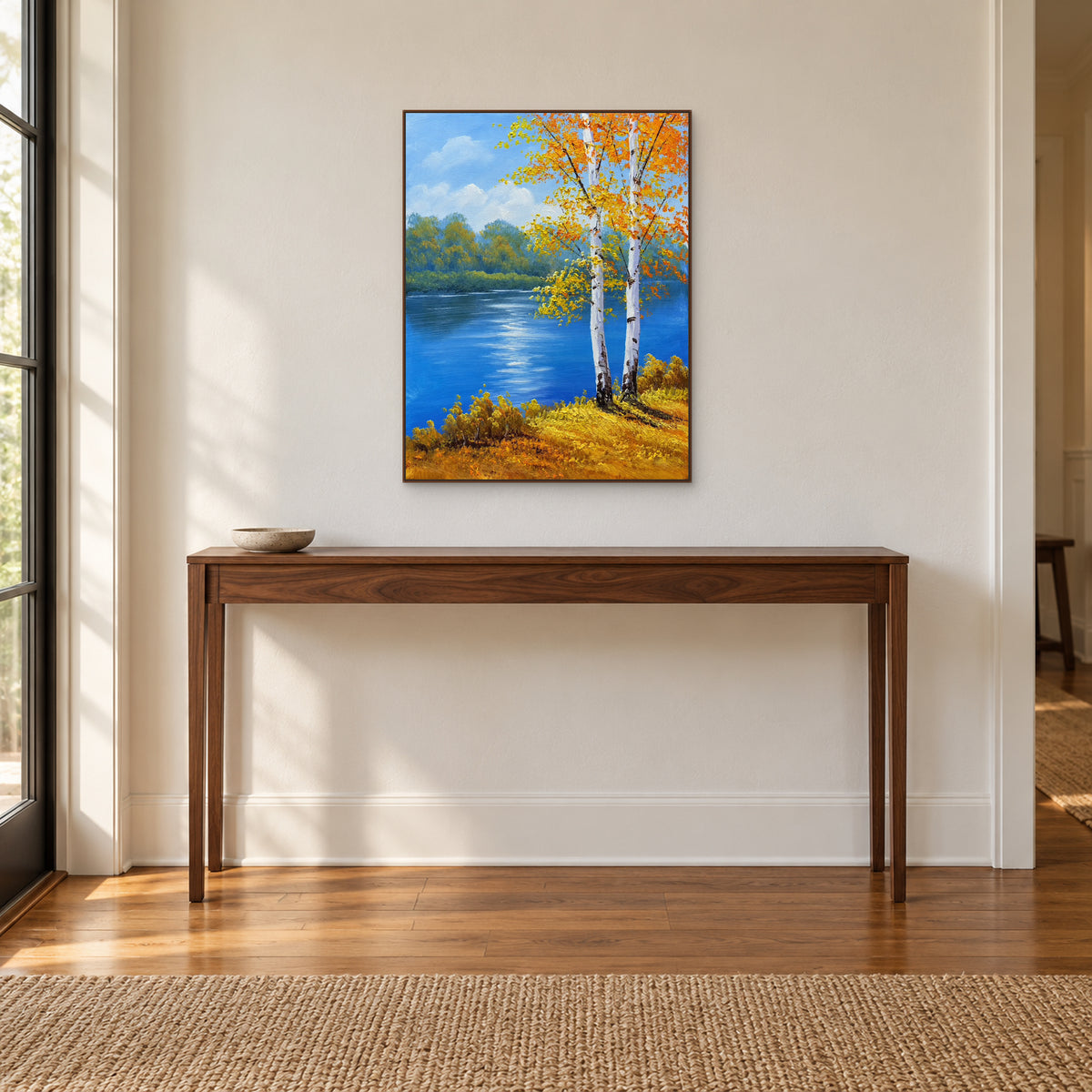 Golden autumn birch painting in a walnut-toned frame centred over a wooden entryway console