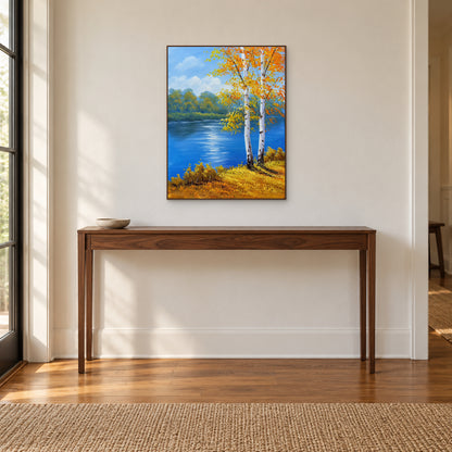 Golden autumn birch painting in a walnut-toned frame centred over a wooden entryway console