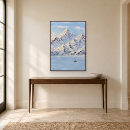 Snowy peaks and still lake painting in a walnut-tone floating frame above a wooden entryway console