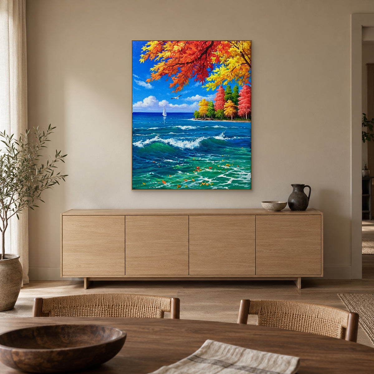 Autumn branches and turquoise sea in a champagne-tone frame above a pale oak-tone dining-room sideboard