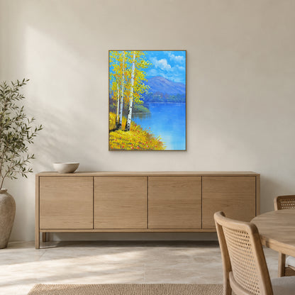 Golden birches and violet mountains in a champagne-toned frame above a light-wood dining room sideboard.