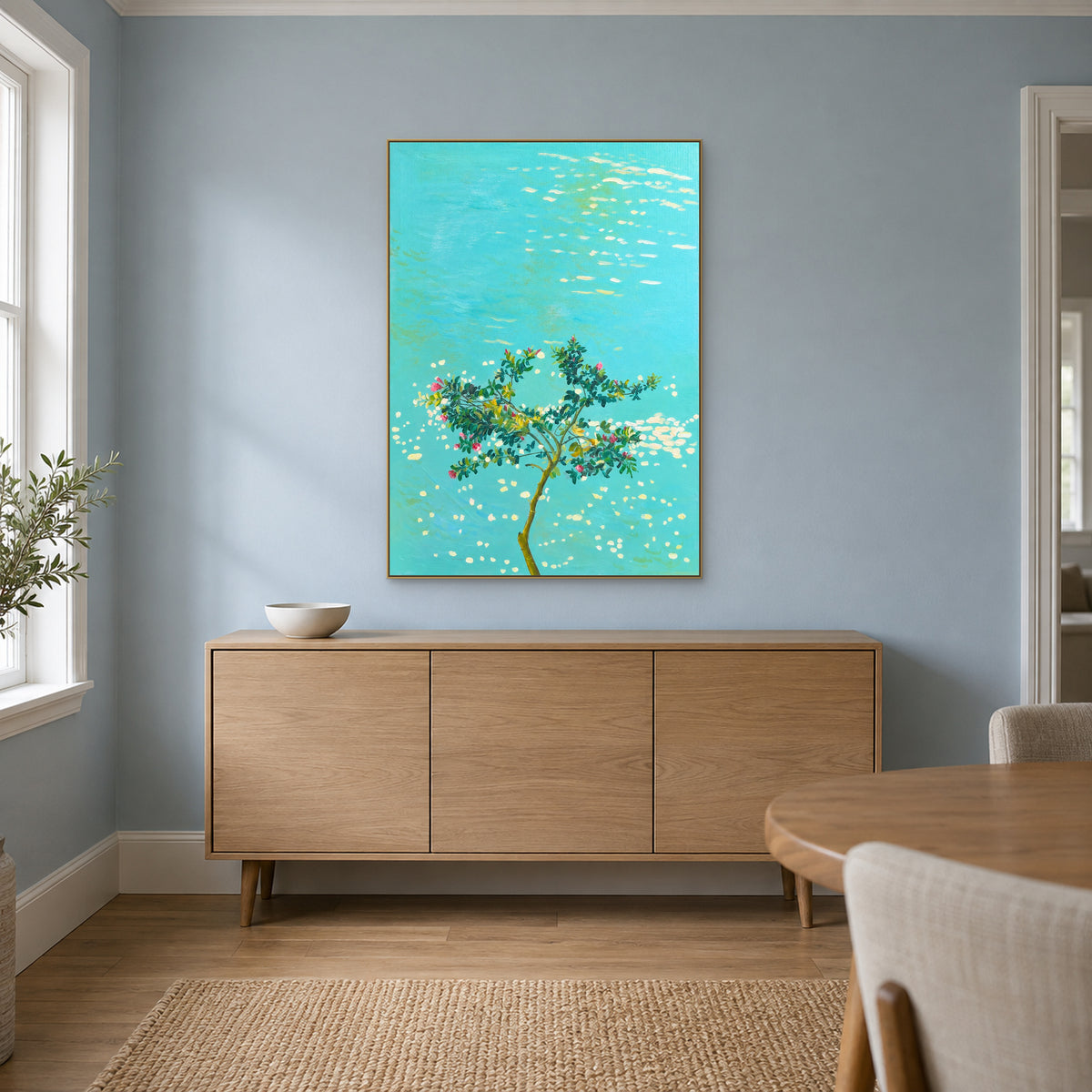 Blossoms over Turquoise in a champagne-tone frame above an oak-tone sideboard on a powder blue dining-room wall