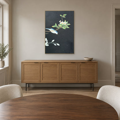 Champagne-framed bird and floral painting above an oak-tone sideboard behind a round dining table