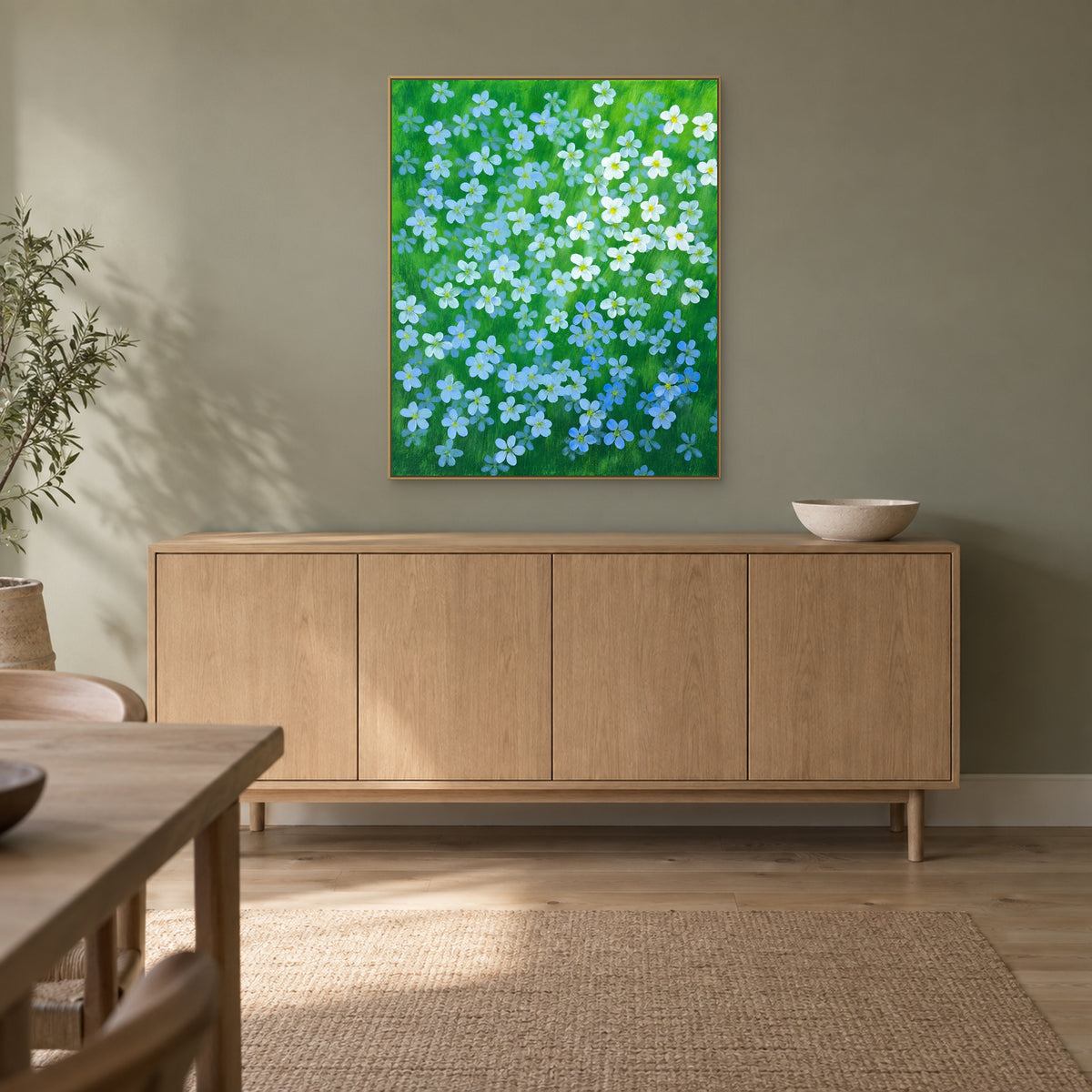 Blue flax botanical painting in a champagne floating frame in a softly lit dining room