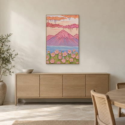 Pink mountain and blue lake painting in a champagne-tone frame above a light wooden dining-room sideboard