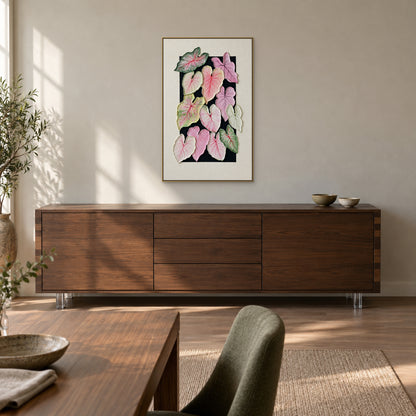 Caladium leaf painting in a champagne-tone floating frame above a smoked-oak dining-room sideboard