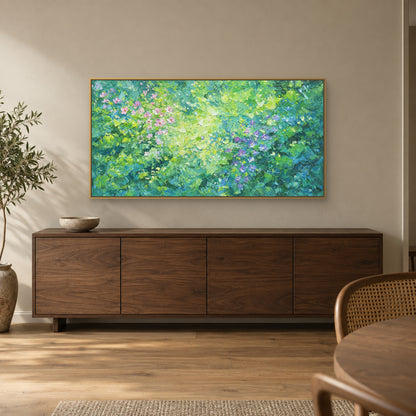 Green and violet floral art in a champagne-toned floating frame above a dark wood credenza beside a cane dining chair