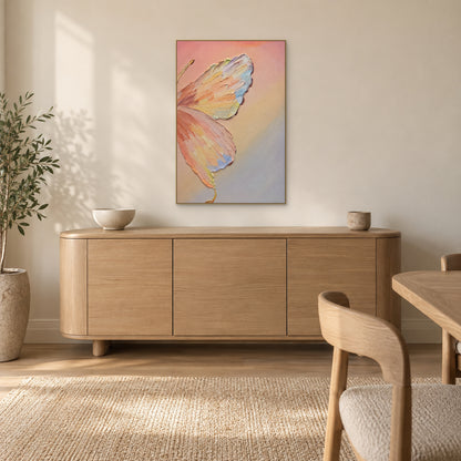 Pastel butterfly in a champagne-tone floating frame above a rounded oak-tone sideboard