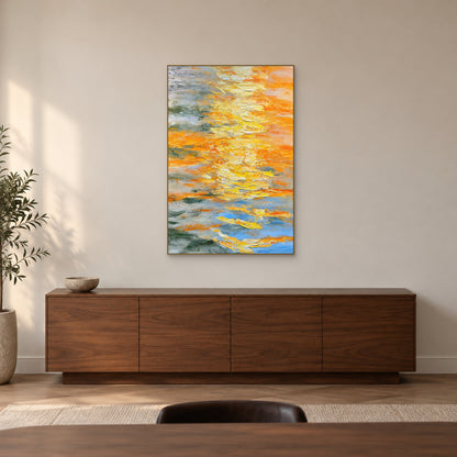 Layered yellow abstract painting in a champagne-toned frame above a walnut sideboard in a softly lit dining room