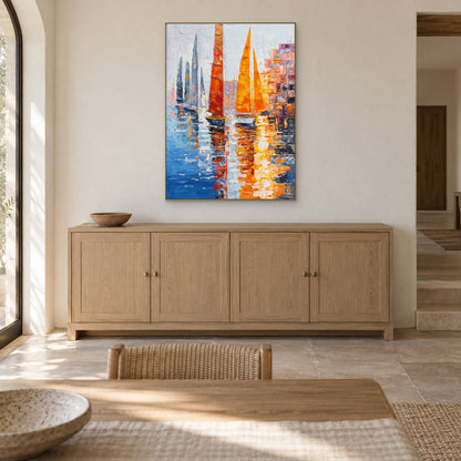 Colourful sailboat painting in a champagne-tone floating frame above an oak sideboard