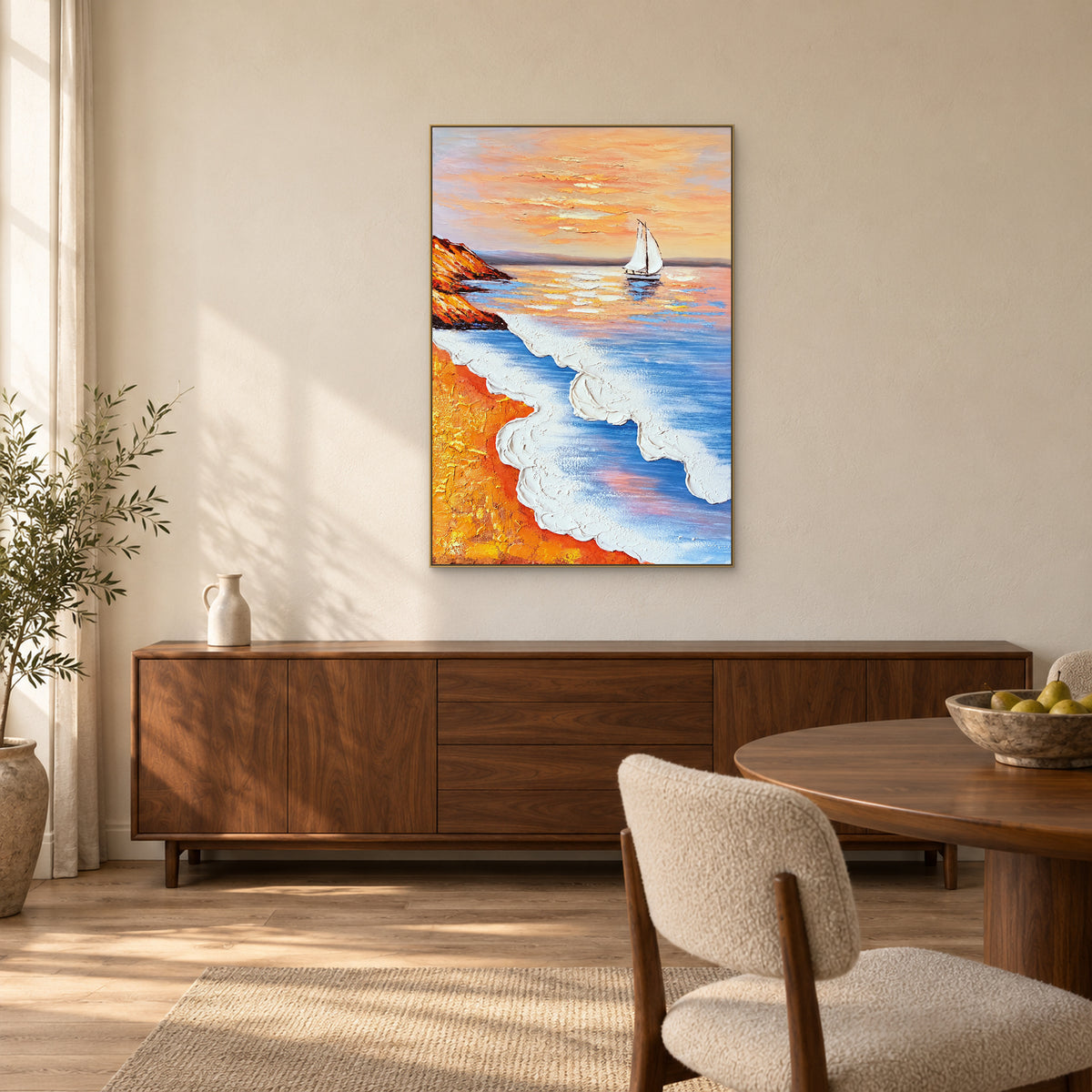 Ochre shore and white sailboat painting in a champagne frame above a walnut sideboard beside a dining table.