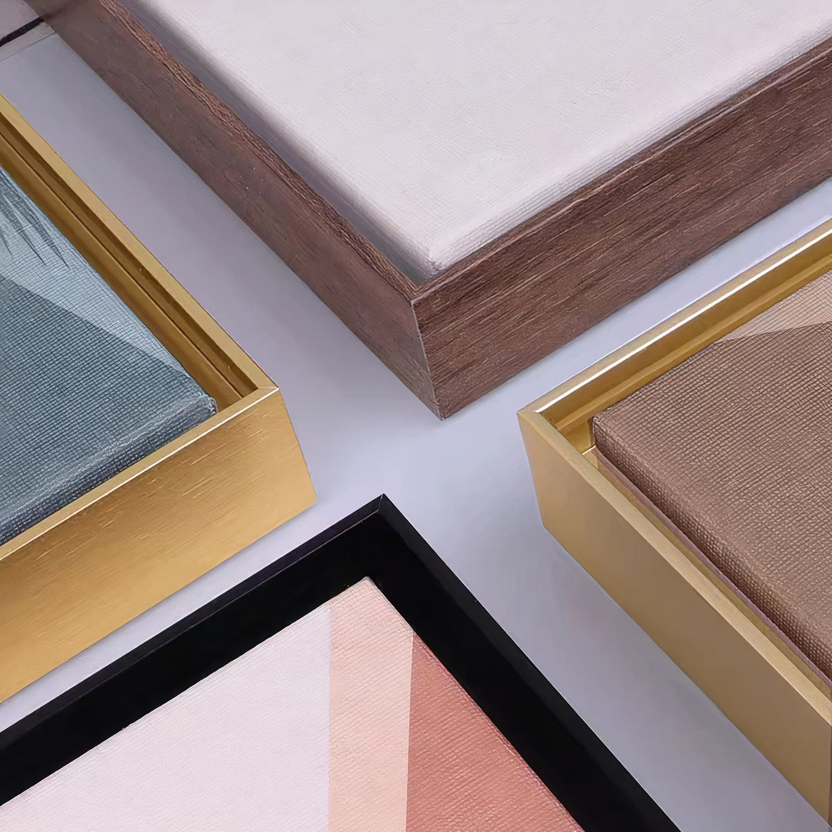 Close-up of floating frame corners in wood tone, gold and black, with a recessed gap around the canvas
