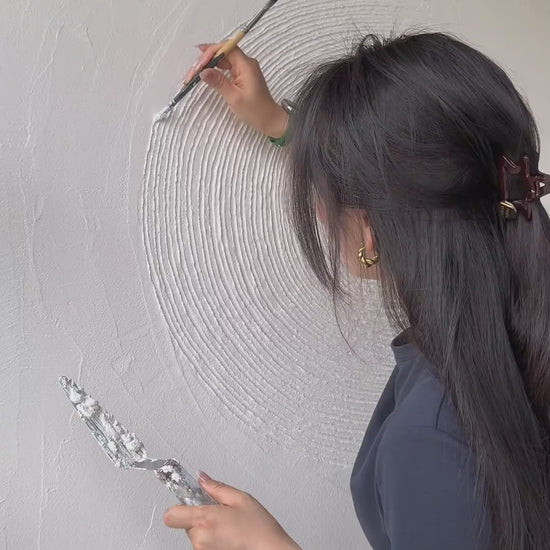 Hand-carving and colouring circular relief, touching the finished texture, and showing the neutral artwork in a room.