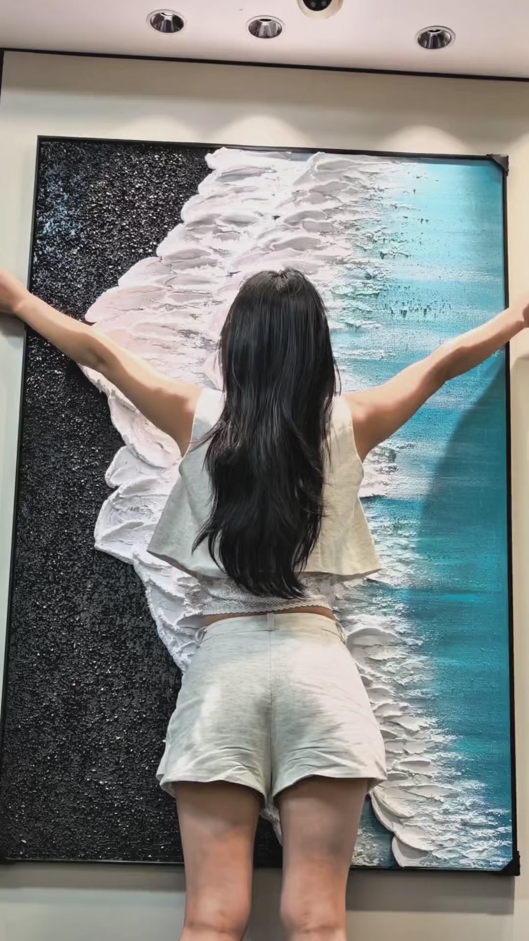 Full coastal painting shown beside a person, followed by close views of dark grain and raised white foam