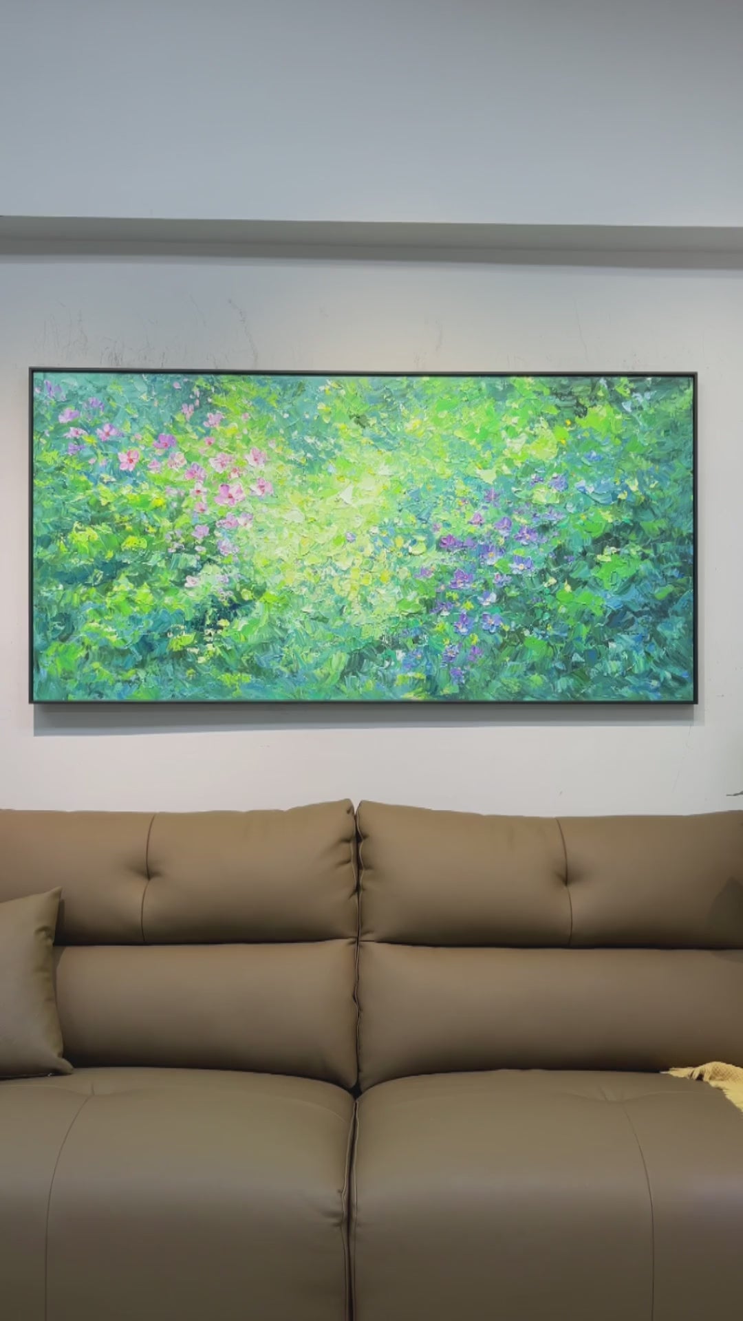 Real video of pink and violet painted flowers, green foliage and ridged paint details, ending with the full artwork above a sofa